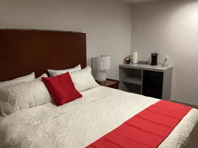 a bedroom with a bed with a red and white blanket at Bethel hotel Elk Point in Elk Point