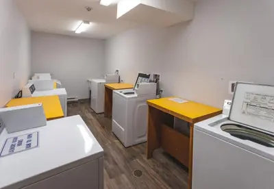a room with a row of washers and dryers at The Ridge Ski-In Ski-Out Condo with Free Parking in Big White