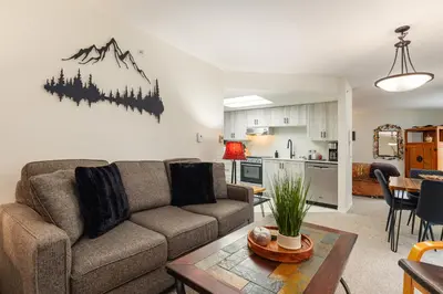 a living room with a couch and a table at The Maple Ski-in Ski-out 1 Bed with Hot Tub and Pool in Whistler