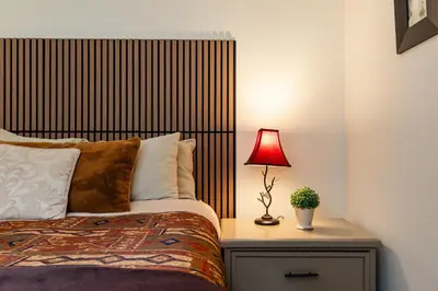 a bedroom with a bed and a lamp on a night stand at The Maple Ski-in Ski-out 1 Bed with Hot Tub and Pool in Whistler