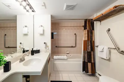a bathroom with a sink and a tub and a toilet at The Maple Ski-in Ski-out 1 Bed with Hot Tub and Pool in Whistler