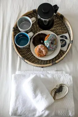 a table with a plate of donuts and cups of coffee at Lovely 2 bedroom suite steps from The beach in Victoria