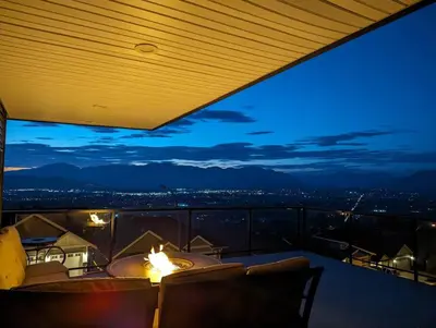a room with a view of the city at night at Mountain Retreat with Views, Hot Tub, Games & AC in Chilliwack