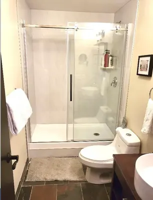 a bathroom with a shower and a toilet at Luxury 2 Bedroom 1Pullout Kitchenette Grand Rockies Resort Hot Tub Pool Mountain View in Canmore