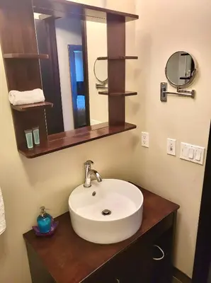 a bathroom with a white sink and a mirror at Luxury 2 Bedroom 1Pullout Kitchenette Grand Rockies Resort Hot Tub Pool Mountain View in Canmore