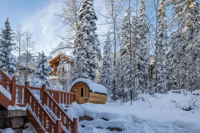 a cabin in the woods with snow on the ground at Copper Horse Lodge in Golden