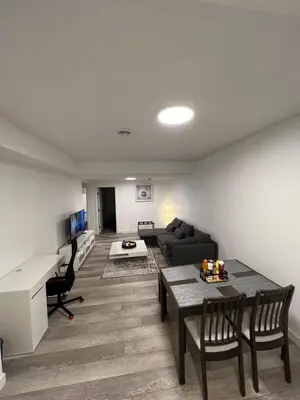 a living room with a couch and a table at 2BR Suite, Private Entry, Full Kitchen, Washer & Dryer, Free Parking, Smart TV with Netflix, High-Speed Wi-Fi, Self Check-In, Near Banff National Park in Calgary