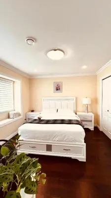 a bedroom with a large white bed and a window at Coze home in Vancouver near YVR in Vancouver