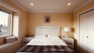 a bedroom with a bed and a window at Coze home in Vancouver near YVR in Vancouver