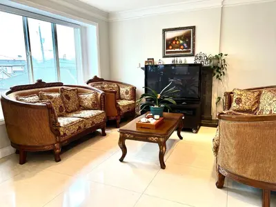 a living room with chairs and a tv and a table at Coze home in Vancouver near YVR in Vancouver