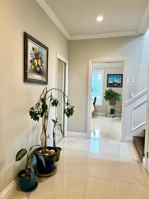 a hallway with potted plants and a painting on the wall at Coze home in Vancouver near YVR in Vancouver