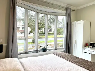 a bedroom with a bed and a large window at Coze home in Vancouver near YVR in Vancouver