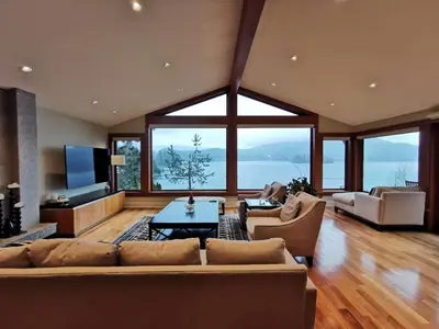 a large living room with a couch and a table at Deep Cove Stunning Waterfront Whole House in North Vancouver