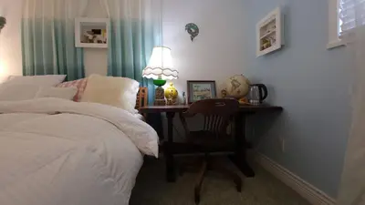a bedroom with a desk with a bed and a lamp at sweet home in Richmond