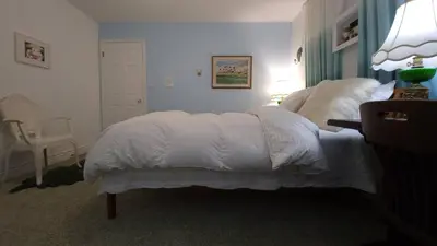 a bedroom with a white bed and a chair at sweet home in Richmond