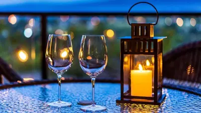 two wine glasses and a candle on a table at Sunrise Valley Suite in West Kelowna