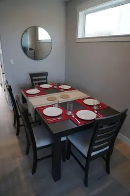 a dining room table with chairs and a mirror at Ocean View Oasis in Campbell River