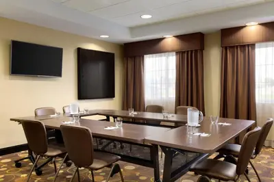 a conference room with tables and chairs and a flat screen tv at Staybridge Suites West Edmonton by IHG in Edmonton