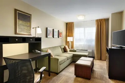 a living room with a couch and a table in a hotel room at Staybridge Suites West Edmonton by IHG in Edmonton