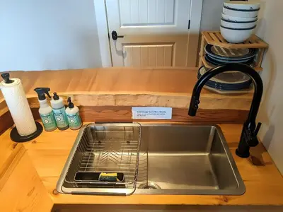 a kitchen sink with a dish drying rack next to it at Mountain House of Wonder in Qualicum Beach