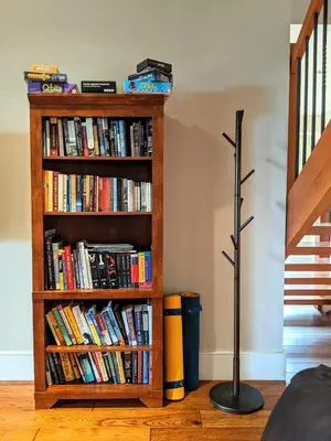 a book shelf filled with books next to a lamp at Mountain House of Wonder in Qualicum Beach