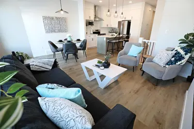 a living room with a couch and chairs and a table at Stylish Home with AC, 3 King Beds, Garage, Disney in Edmonton