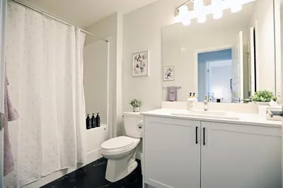 a white bathroom with a toilet and a sink at Stylish Home with AC, 3 King Beds, Garage, Disney in Edmonton