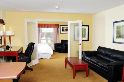 a living room with a couch and a bed at Trend Mountain Hotel & Conference Centre in Tumbler Ridge