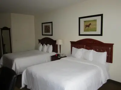 a hotel room with two beds with white sheets at Trend Mountain Hotel & Conference Centre in Tumbler Ridge