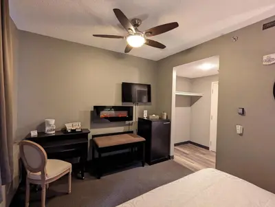 a bedroom with a desk and a bed with a ceiling fan at King Edward Hotel in Banff