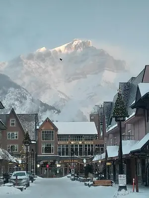 a mountain in the background of a town with snow at King Edward Hotel in Banff
