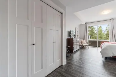 a white bedroom with a bed and a sliding door at Heaven's Haven in Vernon