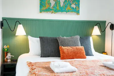 a bedroom with a bed with a green headboard at The Ski Shanty by Revelstoke Vacations in Revelstoke