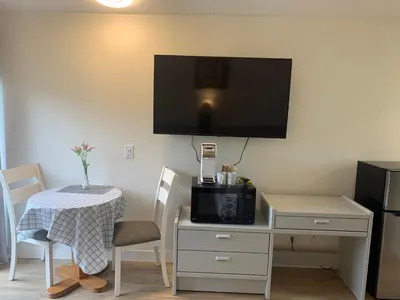 a room with a table and a desk with a microwave at Destination Inn Cache Creek in Cache Creek