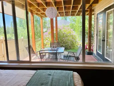 a bedroom with a view of a patio with a table at Private, Spacious, & Bright Home in Calgary