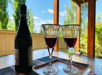 a bottle of wine and two glasses on a table at Private, Spacious, & Bright Home in Calgary