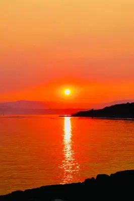 a sunset over a large body of water at EdgeWater Chemainus in Chemainus