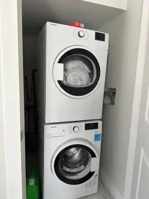 a washer and a washing machine in a room at Bright and cozy modern home in Vancouver - central to YVR-Downtown - Free Private Parking in Vancouver