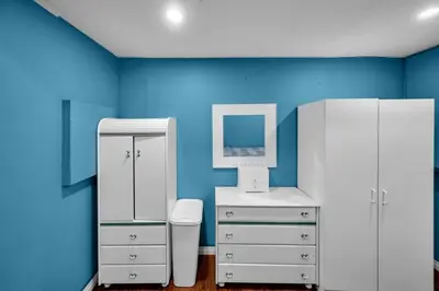 a bathroom with blue walls and a white cabinet at 52-3 Bed Suite On Lake Central Ac By Airport in Calgary
