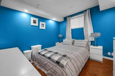 a blue bedroom with a bed and blue walls at 52-3 Bed Suite On Lake Central Ac By Airport in Calgary