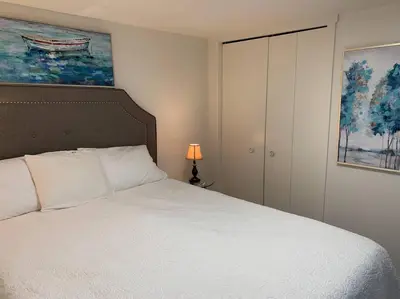 a bedroom with a white bed and a painting at Cosy country mobile home on 18 acres farm sleeps 5 in Port Alberni