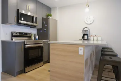 a kitchen with a stove and a microwave at Enchanted Mountain Getaway in Canmore