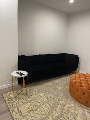 a living room with a black couch and a table at Grande Villa in Calgary