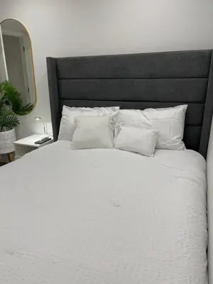 a large white bed with white pillows in a bedroom at Grande Villa in Calgary
