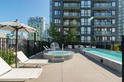 a patio with a pool and chairs and an umbrella at Level Vancouver Yaletown Seymour in Vancouver