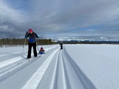 a group of people cross country skiing in the snow at Oma's and Opa's Northern Lights Viewing Cabin in Whitehorse