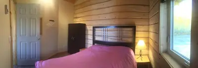 a bedroom with a bed and a brick wall at Oma's and Opa's Northern Lights Viewing Cabin in Whitehorse