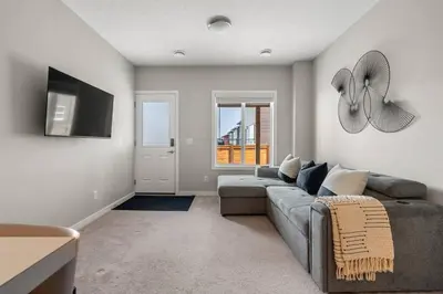 a living room with a couch and a tv at Modern Basement Gem: 2 BR Retreat in Calgary