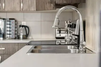a kitchen sink with a faucet on top of it at Modern Basement Gem: 2 BR Retreat in Calgary