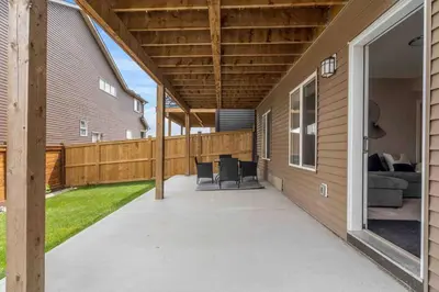a covered patio with a couch and a house at Modern Basement Gem: 2 BR Retreat in Calgary
